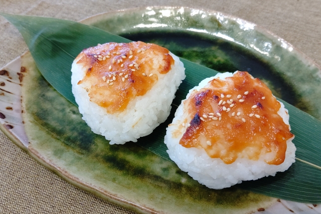 おにぎりの上に味噌が載っている。手前に味噌汁